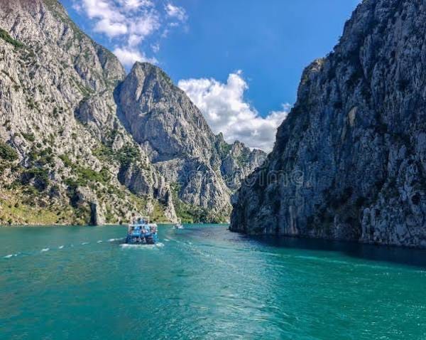 Импресивна фотографија која покажува како траектот плови низ огромните, стрмни фјордови и кањони на езерото Коман